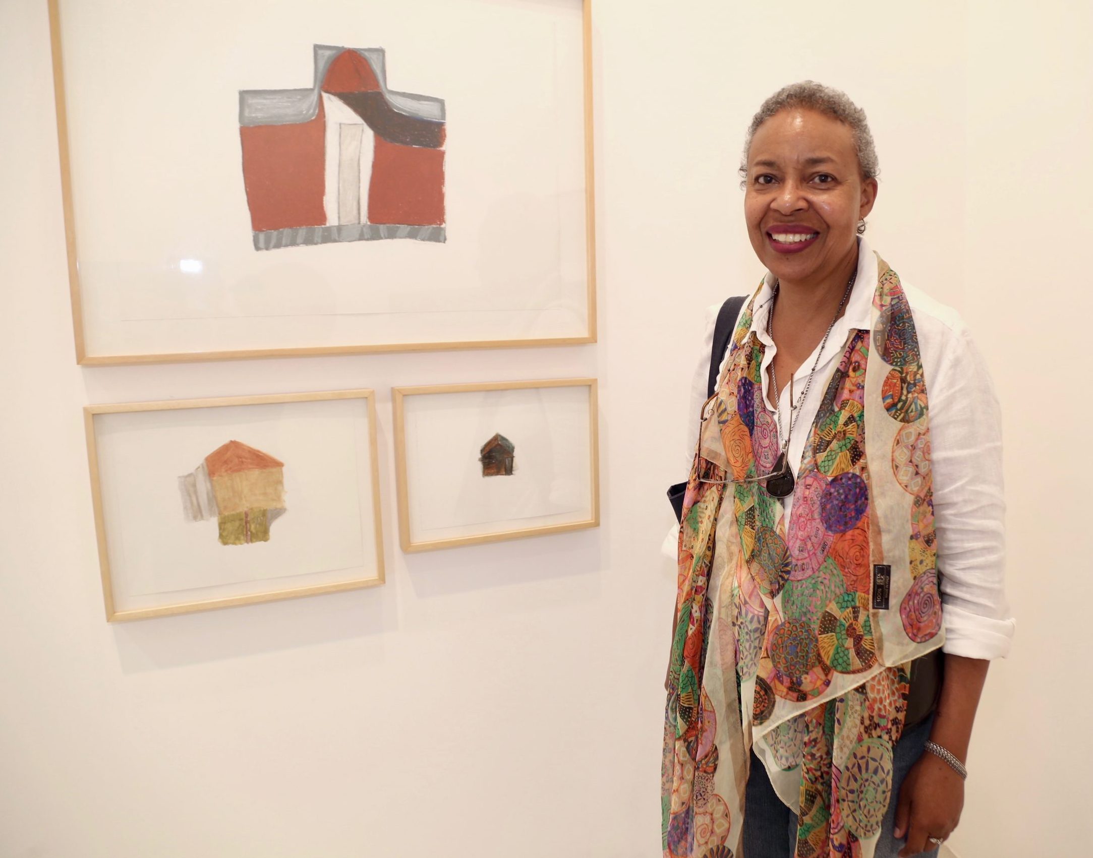 A artista Marga Ledora, ao lado de seus desenhos na Aura Galeria.